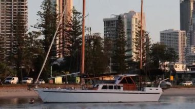 Yelkenliler altın saatinde şehir manzarasının önünden geçiyor