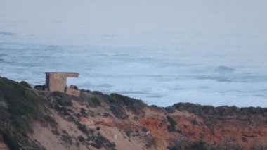 Uçurumun kenarındaki tarihi kalenin yakınlarında dalgalar çarpışıyor