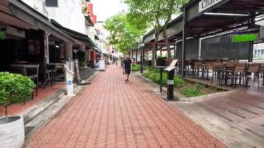 Yayalar açık bir alışveriş alanında yürüyorlar..