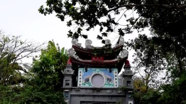 Etrafı yeşilliklerle çevrili sakin bir tapınak girişi