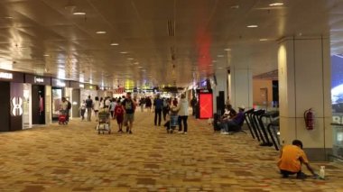 Terminalde yürüyen, oturan ve alışveriş yapan yolcular