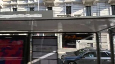 Milano 'daki tarihi binaların önünden geçen araçlar