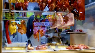 Şef meşgul bir mutfakta kızarmış ördek hazırlıyor.