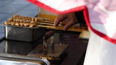 Bir satıcı tarafından sıralı domuz rostosu hazırlama