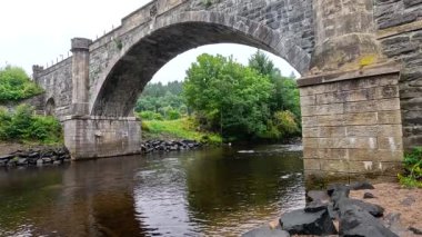 Sakin bir taş köprü, sakin bir nehri aşar.