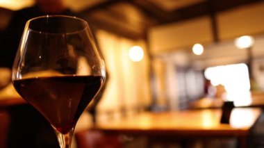 Sıcak bir ortamda kırmızı şarap kadehinin yakın çekimi.