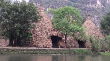 Değişen ışık ve gölgeli bir nehrin kıyısındaki kulübelerde..