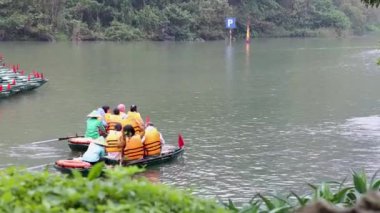 Turistler nehirde tekne yolculuğunun keyfini çıkarırlar.
