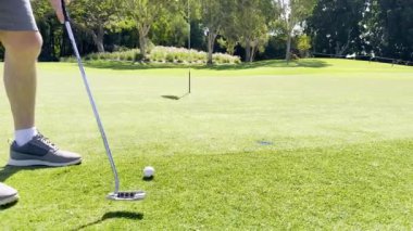 Golfçü topu deliğe doğru atıyor.
