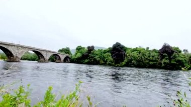 Tarihi köprüsü olan sakin bir nehir manzarası.