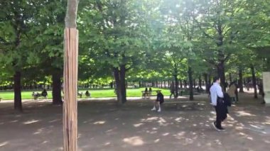 İnsanlar parkta yürüyor ve dinleniyor.