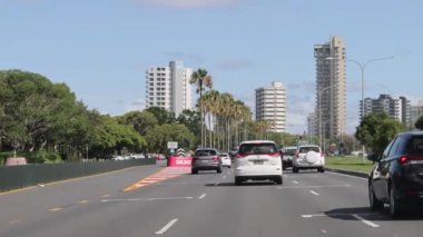 Araçlar çok şeritli bir şehir yolunda ilerliyor.