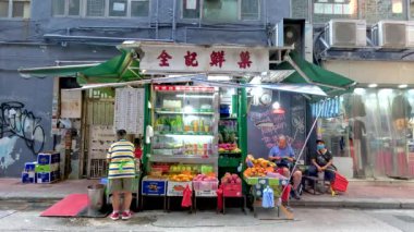 İnsanlar hareketli bir sokak pazarının önünden geçiyor.