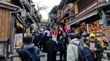 Turistlerin ve geleneksel dükkanların olduğu kalabalık bir sokak.