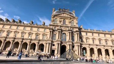Louvre Müzesi avlusunu gezen ziyaretçiler