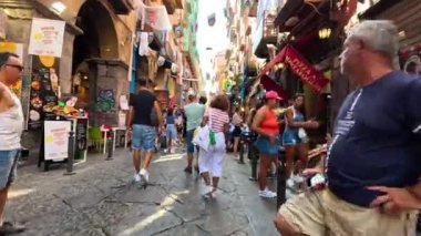 Napoli caddesinde insanlar yürüyor ve alışveriş yapıyor.