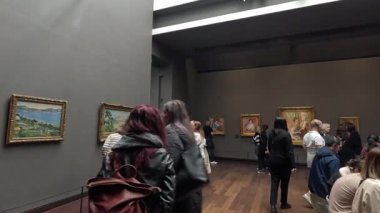 Bir sanat galerisinde resim gözlemleyen ziyaretçiler