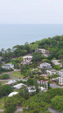 Avustralya 'nın Port Douglas kentindeki yemyeşil ve kıyı binalarını yumuşak gün ışığında sakin bir atmosferle görüntüler.