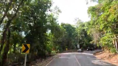 Yeşilliklerle çevrili dolambaçlı bir yolda bir yolculuk