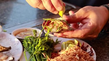 Eller istiridyeleri otlar ve soslarla hazırlıyor.