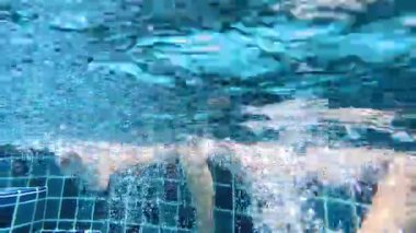 Yüzme havuzunda su sıçratan ayaklar.