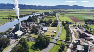 İnsansız hava aracı görüntülerinde yemyeşil manzaralarla çevrili bir şeker değirmeni ve açık gökyüzünün altında dolambaçlı bir nehir görülüyor.