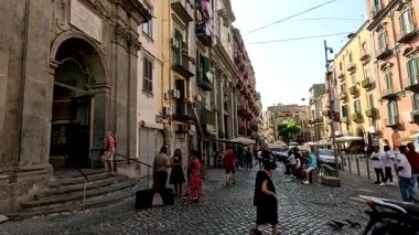 İnsanlar hareketli bir sokak pazarından alışveriş yapıyorlar.