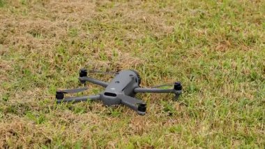 Bir dron çimenli bir alandan yükselir, gün ışığında sabit bir kamerayla yakalanır, pürüzsüz bir kalkış sergiler.