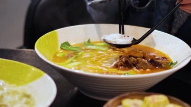 Erişte çorbası hazırlayan ve yiyen kişi.