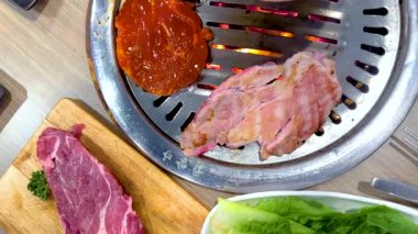 Barbeküde et ızgarası ve canlı mezeler. Ilık aydınlatma mutfak deneyimini geliştirir.