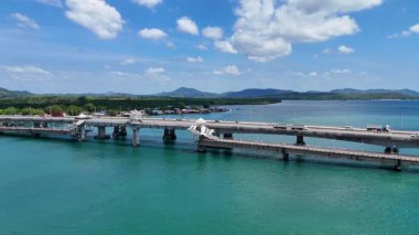 İnsansız hava aracı görüntüleri Phuket, Tayland 'daki Sarasin Köprüsü' nü açık gökyüzünün altında görüntüledi. Turkuaz su ve yemyeşil arazi dingin bir atmosfer yaratır.