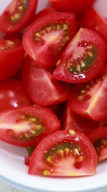 Dilimlenmiş domates, salatalık, arpacık soğanı, sarımsak ve biber parlak ışıklandırmalı tezgahın üstündeki kaselerde dizilmiş.