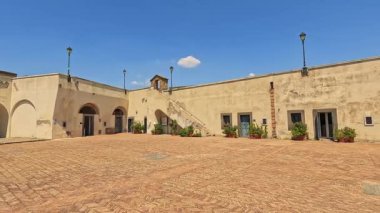 Tarihi mimarisi ve mavi gökyüzü olan sessiz bir avlu.