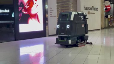 Bir robot temizleyici, Auckland Havaalanı 'nın vergisiz bölgesinde modern bir perakende satış ortamında ileri teknoloji sergiliyor.