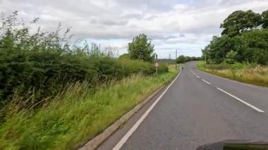 Bisikletçi Edinburgh yakınlarındaki yemyeşil kırlarda seyahat ediyor.