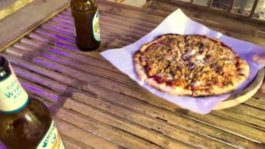 Tahta bir masada pizza ve bira.
