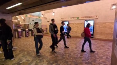 İnsanlar metro istasyonunda yürüyor.