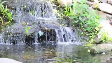 Sakin şelale kayaların üzerinden göle akıyor