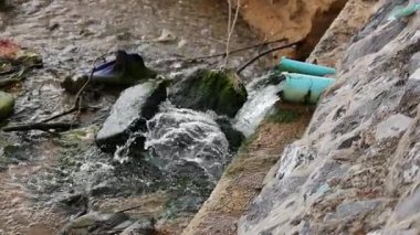 Beton drenaj kanalından akan su, kentsel fırtına suyu yönetimi ve kirlilik sorunlarını vurguluyor