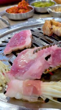 Bangkok 'taki Kore mangalında et ızgarası. Canlı renkler, dinamik kamera açıları ve canlı bir atmosfer.