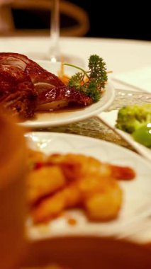 Yumuşak ışıklandırmalı sıcak, davetkar bir restoran ortamında sunulan çeşitli Dim Sum yemekleri.