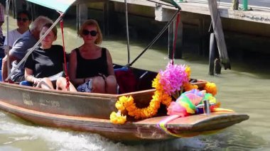 Yüzen pazarda bir teknede turistler