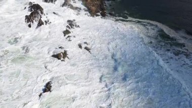 İnsansız hava aracı görüntüleri, Avustralya 'nın Byron Körfezi' ndeki kayalık kıyı şeridine çarpan güçlü dalgaları yakalıyor. Gün ışığı altında doğanın dinamik güzelliğini gösteriyor.