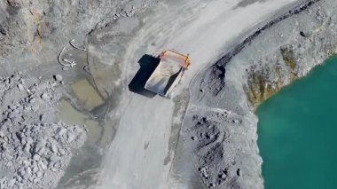 İnsansız hava aracı, Avustralya 'nın Gold Coast kentindeki turkuaz bir gölün yanındaki taş ocağında yol alan bir maden kamyonunu yakalıyor.