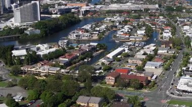 Havadan çekilen görüntüler, canlı bir şehir mahallesini kanallarla, sergilenen konut mimarisi ve parlak gün ışığında yemyeşil alanlarla yakalıyor.