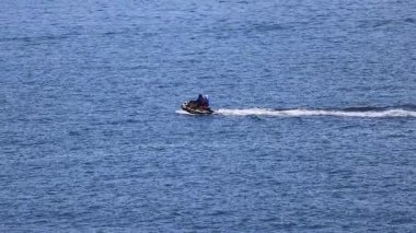 Bir jet ski, Phuket, Tayland 'da, açık gökyüzünün altında hızla süzülerek özgürlük ve macera hissini yakalar.
