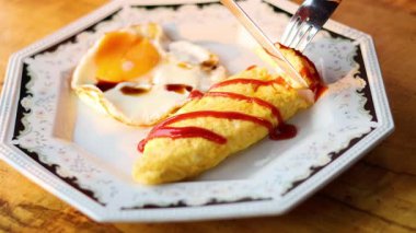 Çatal ve bıçak tabakta omlet kesiyor