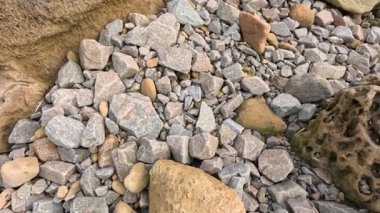 Melbourne sahilinde çakıl taşları ve aşınmış kumtaşı