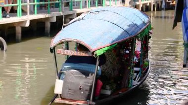 Bir tekne hareketli yüzen bir pazarda manevra yapar.
