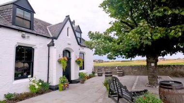 Bahçesi ve fıçıları olan beyaz bir ev.